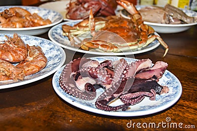 Many different seafood lobster shrimp octopus crabs dish lie on meze plates Stock Photo