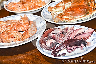 Many different seafood lobster shrimp octopus crabs dish lie on meze plates Stock Photo