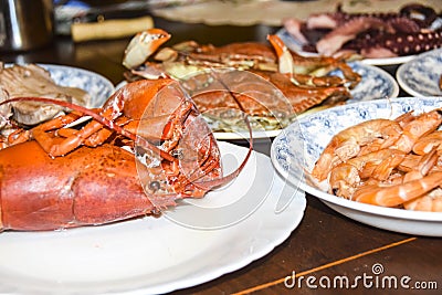 Many different seafood lobster shrimp octopus crabs dish lie on meze plates Stock Photo