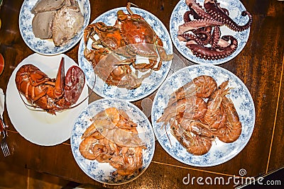 Many different seafood lobster shrimp octopus crabs dish lie on meze plates Stock Photo