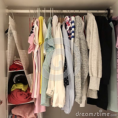 many different things hang and lie in the closet in the wardrobe. Stock Photo