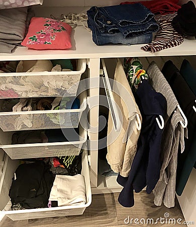 many different things hang and lie in the closet in the wardrobe. Stock Photo