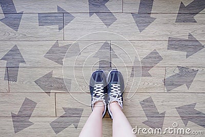 Many Direction Arrow Choices. Selfie of Running Shoes with Drawn Arrows. Woman Violet Sneakers with Decisions on Wooden Floor Back Stock Photo