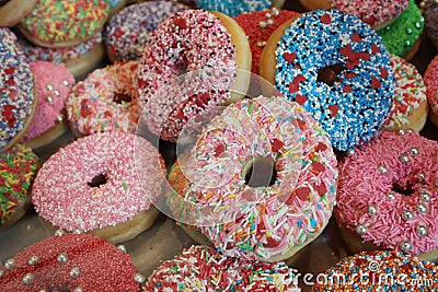 So many donuts covered with icing and colorful sugars Stock Photo