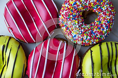 Many donuts of different colors lie next to each other Stock Photo