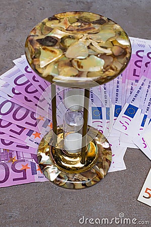 many 500 euro banknotes background with hourglass. EU currency Stock Photo