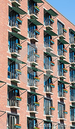 Many Flower Boxes on Brick Building Balconies Stock Photo