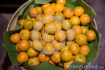 Many fresh and beautiful Oranges with a good taste in the basket at the market. Many orange put on shelves in the market. Stock Photo
