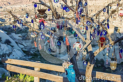 Many glass mascots - evil eye charms hang from a tree in Cappadocia, Pigeon valley, Turkey . Stock Photo