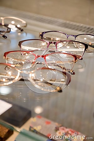 Many glasses rows at optical retail store. Rich assortment choice of different eyewear frames on eyeglasses shop display Stock Photo