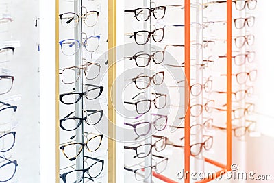 Many glasses rows at optical retail store. Rich assortment choice of different eyewear frames on eyeglasses shop display Stock Photo