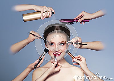 Many hands with cosmetics brush, shadows doing make up Stock Photo