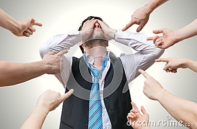 Many hands pointing at disappointed man and blame him Stock Photo