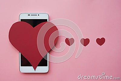 Valentine and smartphone. The concept to like in social networks or Dating app. pink background Stock Photo