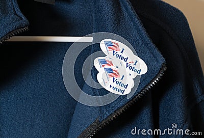 Many I Voted stickers on blue jacket hung on hanger Stock Photo