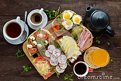 Many kinds of sandwiches, bruschetta, and tea, coffee, fresh juice - for a family breakfast. Stock Photo