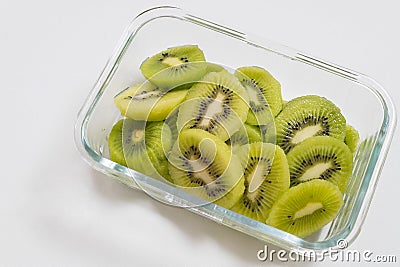 Many kiwi slices are placed in a glass crisper. Kiwifruit slices without peel Stock Photo