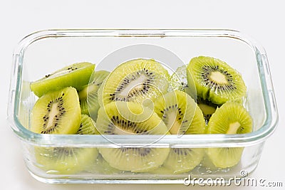 Many kiwi slices are placed in a glass crisper. Kiwifruit slices without peel Stock Photo