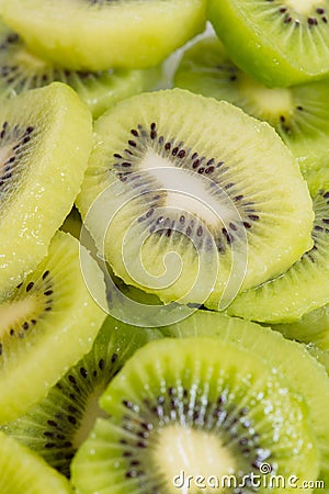 Many kiwi slices are placed in a glass crisper. Kiwifruit slices without peel Stock Photo