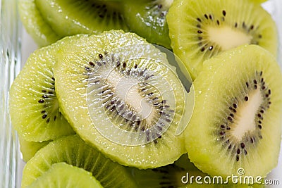 Many kiwi slices are placed in a glass crisper. Kiwifruit slices without peel Stock Photo