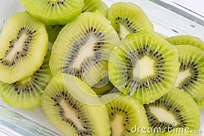 Many kiwi slices are placed in a glass crisper. Kiwifruit slices without peel Stock Photo