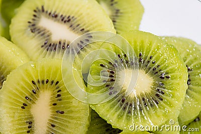 Many kiwi slices are placed in a glass crisper. Kiwifruit slices without peel Stock Photo