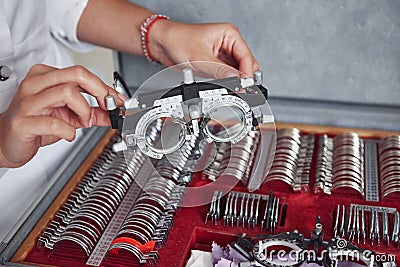 Many of the lenses in the box. Female hands holding the optical device for eye testing Stock Photo