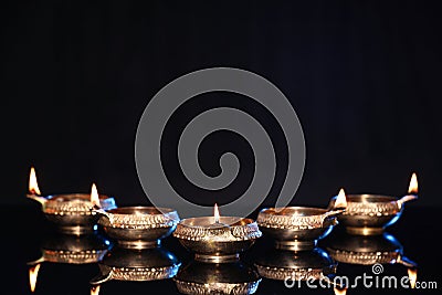 Many lit diyas on black background, space for text. Diwali lamps Stock Photo