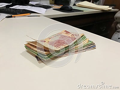 Many mixed Mexican peso bills spread over a beige desk Stock Photo