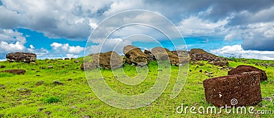 Many moai statues laid down on the ground under the clouds Stock Photo