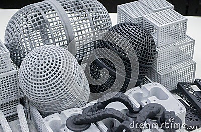 Many models printed on 3D printer. Gray and black objects printed 3D printer. Stock Photo