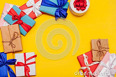 Many multi-colored gifts for the holiday on a yellow background Stock Photo