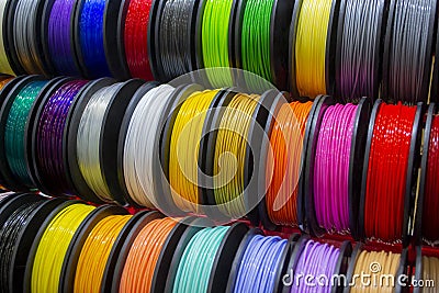Many multi-colored spools coils of thread of filament for printing 3d printer. Stock Photo