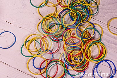 Many multicolored elastic rubbers on wooden table. Top view Stock Photo