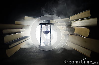 Many old books in a stack. Knoledge concept. Books on a dark background with smoke elements. Bewitched book in center Stock Photo