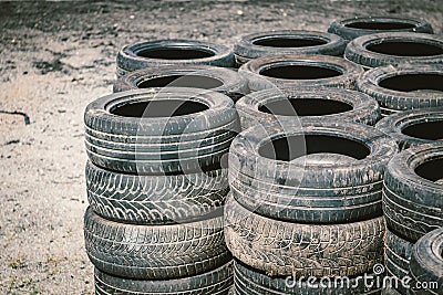 Many old used car tires stacked on top of each other on Automobile sports complex. Industrial landfill for the Stock Photo