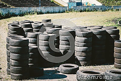 Many old used car tires stacked on top of each other on Automobile sports complex. Industrial landfill for the Stock Photo