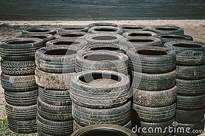 Many old used car tires stacked on top of each other on Automobile sports complex. Industrial landfill for the Stock Photo