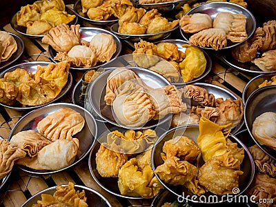 Many oriental crispy deep fried wontons in small stainless steel mini bowl preparing in local restaurant, Chinese dim sum takeaway Stock Photo