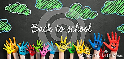 Many painted kids hands with smileys and the message `Back to school` Stock Photo