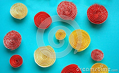 Many Paper spirals yellow and orange on a pastel blue background Stock Photo