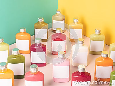 Many pastel color drink in plastic bottle container with empty logo label. mixed many vegetables and fruits smoothie juice on stud Stock Photo