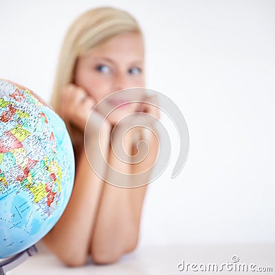 So many places to see...A young woman looking a globe of the earth wondering where to go next. Stock Photo