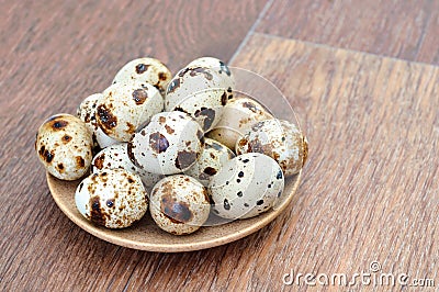 Many Quail eggs in a plate on old wooden table Stock Photo