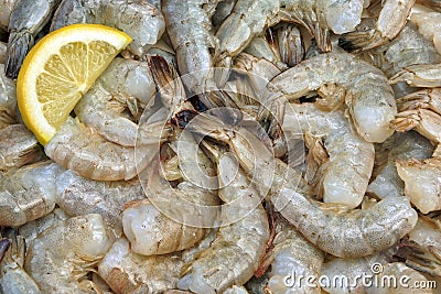 Many Raw Green King Size Shrimps With Lemon Slices Stock Photo