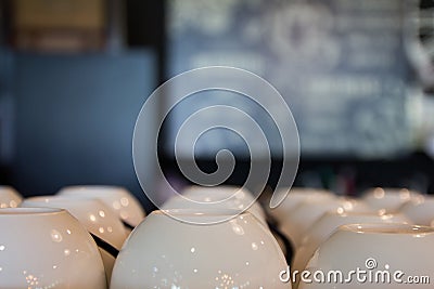 Many rows of clean pure white coffee cups stack set on table at Stock Photo