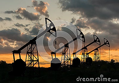 Many silhouettes of drilling oil rigs at sunset Stock Photo