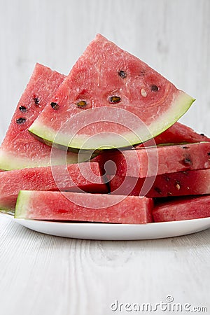 Many slices of ripe juicy watermelon on a round white plate, closeup Stock Photo