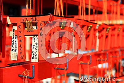 Many small Torii Gate hanging on red wooden hanger at Fushimi Inanari Shrine. People write blessings on amulets and prayed Editorial Stock Photo