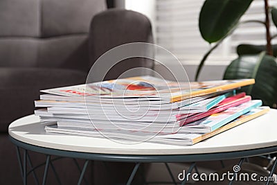 Many stacked magazines on table in room Stock Photo